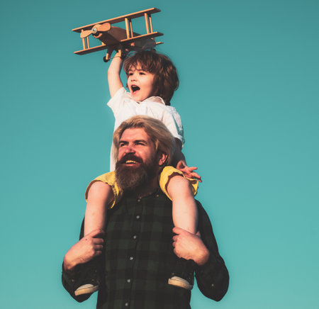 Father and son playing with wooden airplane. Family Time Together.