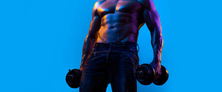 Banner templates with muscular man, muscular torso, six pack abs muscle. Strong man working out with dumbbells on blue background. Man lifting the dumbbells. Strength and motivation.の写真素材