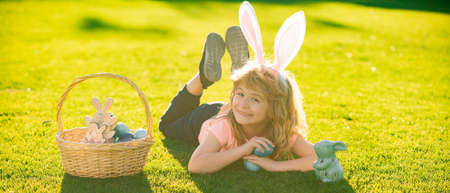 Children celebrating easter. Kid in rabbit costume with bunny ears outdoor. Kids in bunny ears on...