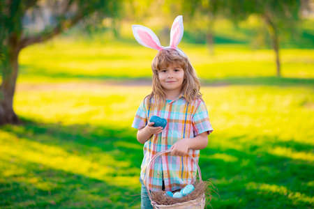 Happy Easter for children. Child boy hunting easter eggs, laying on grass. Kid in rabbit bunny ears...
