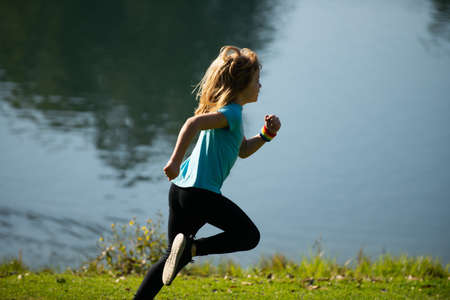 Kid runners run in park. Sporty young child jogging and training outdoor. Active energetic...