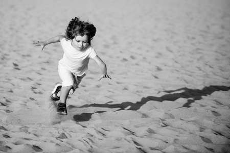 Child play with sand on beach. Active kid having fun on summer vacation.の写真素材