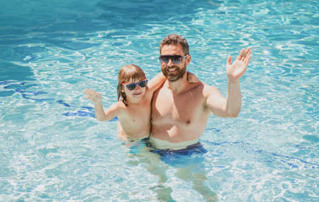 Father and son swimming in pool, summer family. Child with dad playing in swimming pool. Aquapark. Father and son leisure.の写真素材