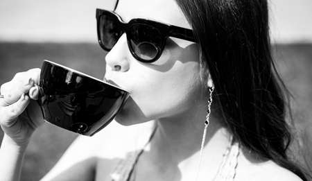 Fashion woman drinking coffee outdoor. Americano cappuccino latte espresso.の写真素材