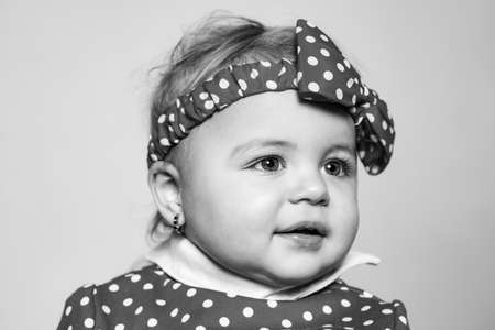 Cute baby girl red polka dot bow on head. Fashion accessory. Fashion for babies. Stylish toddler adorable girl. Happy childhood. Child care concept. Fashion accessory. Little baby small fashion modelの写真素材