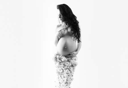 beautiful pregnant woman in spring flower skirt. womens health. girl with big belly. life birth expectation. Love. future mother have baby inside. pregnancy. Maternity preparation. future family.の写真素材