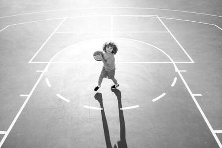 Child boy preparing for basketball shooting, outdoor on playground.の写真素材