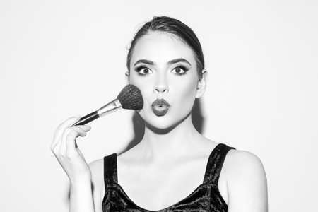 Beautiful amazed woman, female skin care, close up face beauty portrait. Cosmetic Powder Brush.の写真素材