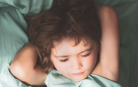 Close up portrait of little boy kids sleeping in bed.の写真素材