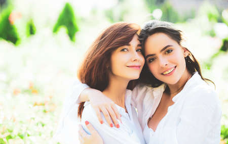 Portrait of young women standing together and looking at camera over green spring background.の写真素材