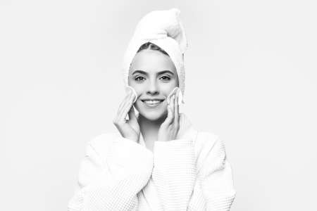 Beautiful young woman touching her face with sponge and smiling.の写真素材