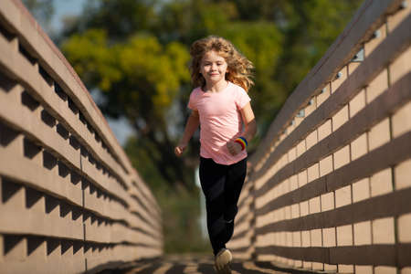 Child boy jogging in park outdoor. Sporty kid running in nature. Active healthy child boy runner jogging outdoor. Morning running with children.の写真素材