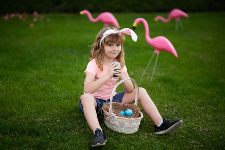 Child in bunny ears hold Easter egg. easter basket Boy hunting easter egg. Easter egg hunt.の写真素材