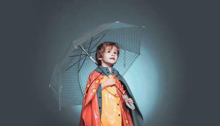 Sale for entire autumn collection, incredible discounts and wonderful choice. Cute little child boy are getting ready for autumn. Cheerful boy in raincoat with colorful umbrella. Kid in rain.の写真素材