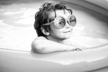 Children playing in pool. Child boy and best swimming pool. Child water toys. Kids learn to swim. Enjoying in swimming pool. Children play in tropical resort.の写真素材