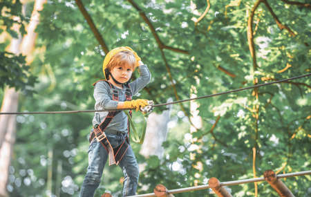 Cute child boy playing. Artworks depict games at eco resort which includes flying fox or spider net....