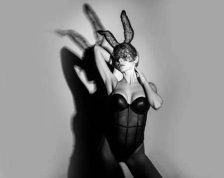 Beautiful, sexy, naked woman in Halloween. Easter bunny costume and black lace mask. Sexy woman with bunny ears.の写真素材