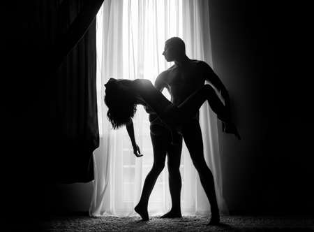 Romantic portrait of a sensual couple in love. Passionate man kissing sensual woman. Embrace and kiss. The Real History of Valentines Day. Loving couple hugging.の写真素材