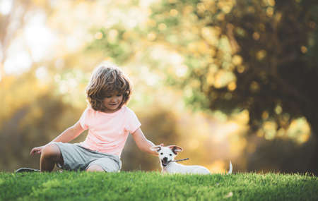 Kid with puppy dog. Portrait child boy with pet.の写真素材