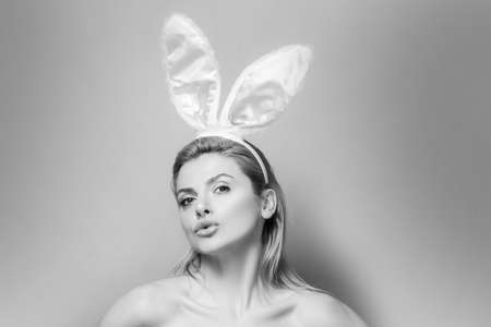Lovely beautiful sensual young woman posing in pink bunny ears. Studio shot of easter girl isolated on pink.の写真素材