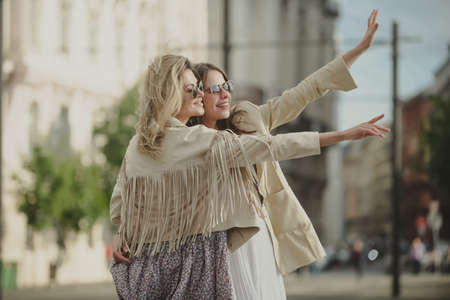 Excited girls friends walking on city. Outdoor portrait of caucasian young women enjoying good day. Happy leisure, carefree weekend and romantic holiday.の写真素材