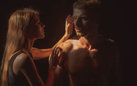 Man embracing and going to kiss sensual woman. Loving couple kissing over black background. Real love on Valentines Day. Sensual couple touching each other. Romantic and love.の写真素材