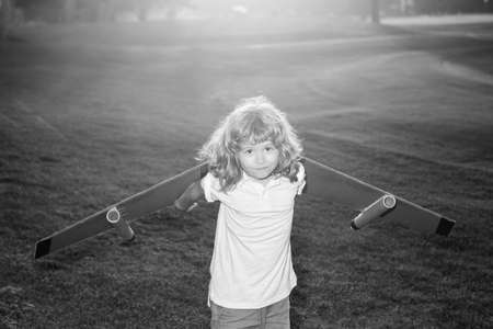 Child playing with toy jetpack at sunset grass field. Child pilot astronaut or spaceman dreams of...