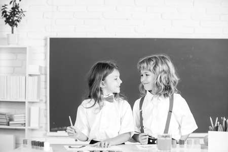 Children girl and boy drawing with coloring pens. Cute school kids painting in class at school. Painting lesson, drawing art. Siblings drawing with pencil and paints.の写真素材