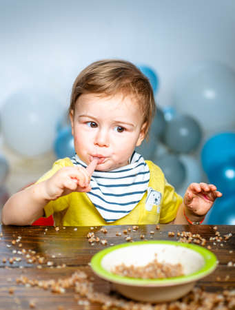 Baby food, babies eating. Funny kid boy with plate and spoon.の写真素材
