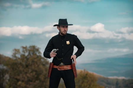 Sheriff or marshal. American western, wild west with cowboy. Serious guy with gun revolver weapon...