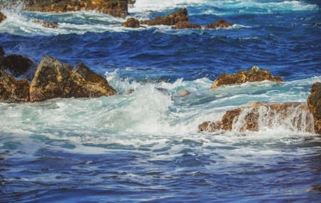 Sea stone beach, sea waves. Colorful blue sea background. The concept of summer vacation and travel....