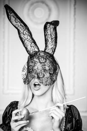 Attractive young woman wearing bunny ears. Close-up portrait. Happy young woman painting eggs. Blonde Girl wearing bunny ears and having Easter Eggs. Cute bunny.の写真素材