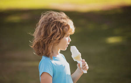 Cute child boy eating ice cream. Close up caucasian kids face. Closeup head of funny kid.の写真素材
