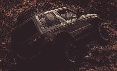 Tracks on a muddy field. Bottom view to big offroad car wheel on country road and mountains...