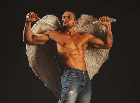Muscle strong beautiful stripped male angel. Handsome young athletic man with a naked torso looks like an angel with white wings. Valentines day.の写真素材