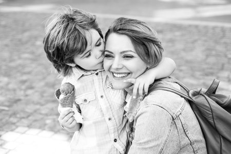 Mother and child eat icecream outdoor. Junk food. Delicious summer ice cream.