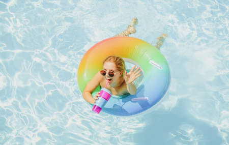 Pool resort. Enjoying vacation. Woman in swimsuit on inflatable circle in the swimming pool.の写真素材