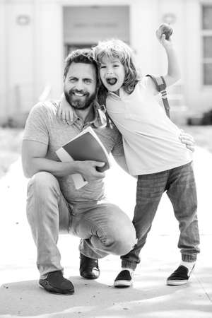 Happy father and son come back from school. School, kids education and outdoor concept.の写真素材
