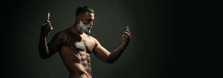 Sexy bearded man shaving. Barber with straight razor, barbershop. Shaving in barber shop. Templates web banner design. Shaving cream, foam. Horizontal banner for website header.の写真素材