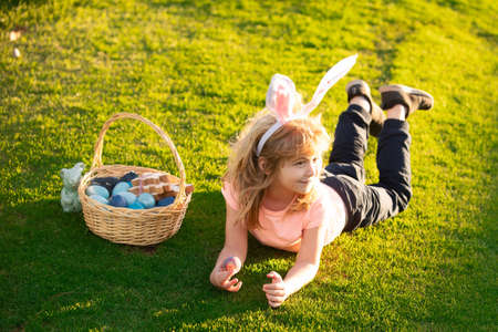 Children celebrating easter. Kid in rabbit costume with bunny ears outdoor. Easter kids with bunny...