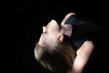 Sensual woman with shadows on beautiful face. Blonde girl closeup profile face.の写真素材