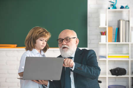 School lesson. Help to learn. Old teacher with pupil. Education concept. Old teacher with schoolboy...