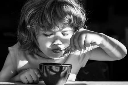 Kids Nutrition. Healthy eating habits. Kids home food. Boy eats breakfast at kitchen.