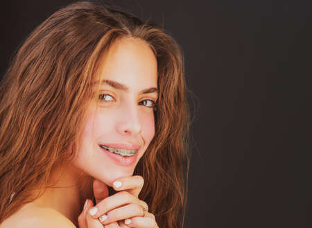 Orthodontics and dentistry. Smiling girl with braces. Teeth alignment.