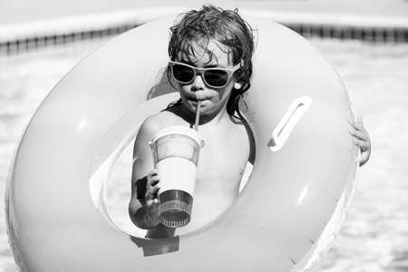 Cocktail on watter pool in the summer. Funny portrait of child. Kid having fun in swimming pool...