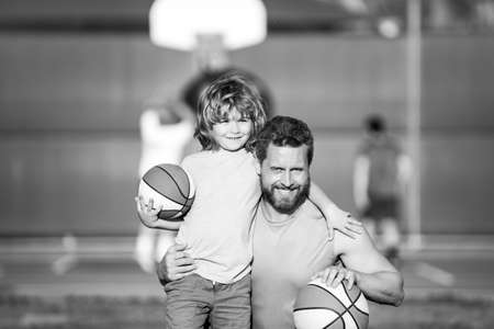 Dad and his son playing basketball. Father and son enjoying sport basketball outdoor. Childhood and parenting concept.の写真素材