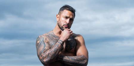 Brutal angry gang man lifestyle, serious handsome guy. Outdoor male portrait on dramatic sky.の写真素材