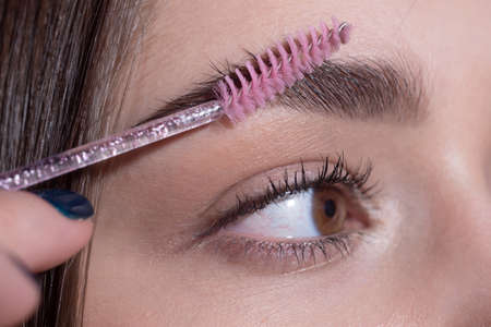 Womans eyebrows. Macro close up of brows. Beautiful girl with eyebrow brush. Girl with natural make...