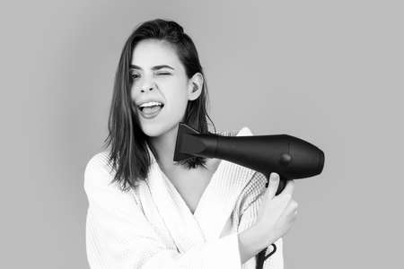 Funny woman blow drying her hair. Young girl with drying hair with hair dry.