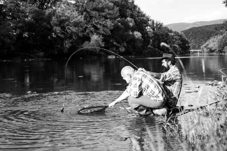 Elegant bearded men fishing. Family day. Man bearded fisher. Keep calm and fish on. Catching and fishing. Retired bearded fisher. Hunting. Summer leisure. Mature man with friend fishing.の写真素材